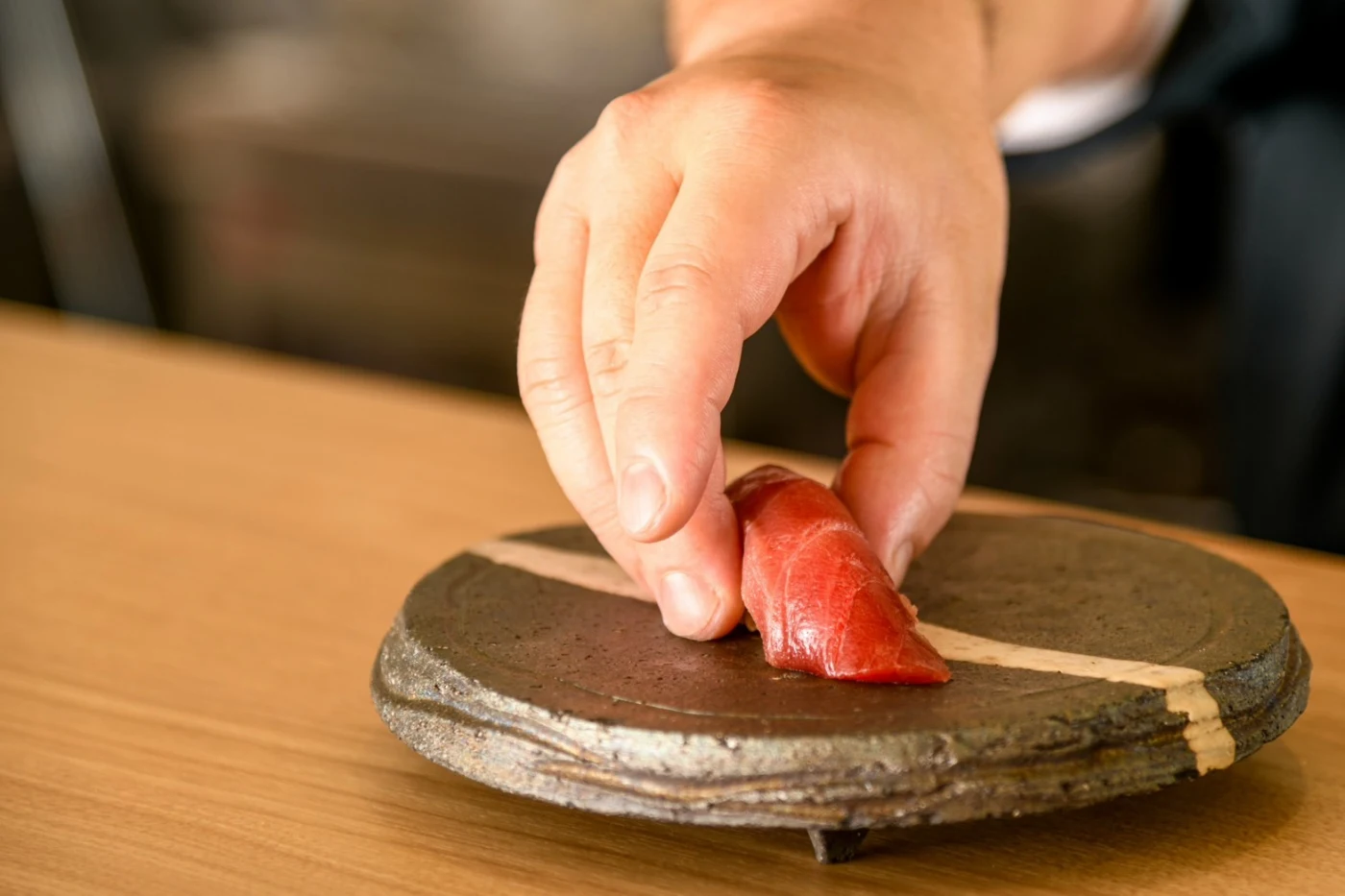 職人の手で握られるマグロの寿司